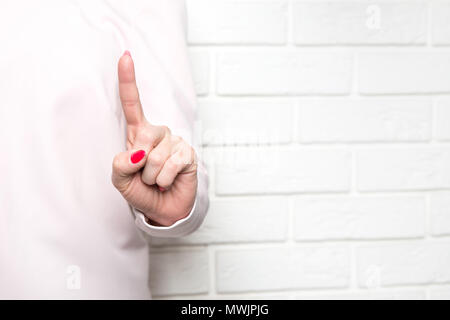 Eine Frau trägt ein rosa Kleid hat ihre Hand erhoben und zeigt mit dem Finger in Richtung der Kamera. Das Konzept der etwas zeigen, Bedrohung mit ihren fin Stockfoto