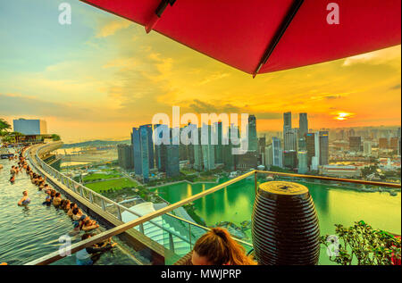 Singapur - Mai 3, 2018: CE LA VI's Club Lounge Sky Deck mit Blick auf den randlosen Pool der Skypark, dass Tops die Marina Bay Sands Hotel. Bankenviertel Skyline im Hintergrund. Sonnenuntergang geschossen. Stockfoto