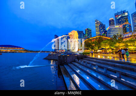 Singapur - 27. April 2018: Merlion Statue im Merlion Park mit Central Business District oder CBD Gebäude beleuchtet in der Marina Bay Hafen und Uferpromenade. Malerische Singapur Symbol an der blauen Stunde. Stockfoto