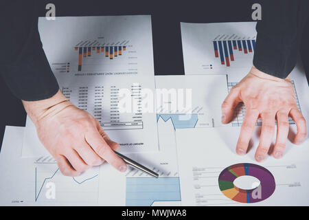 Analyst arbeitet auf Berichte und Diagramme. Der Mann analysiert die Graphen von Berichten, Prüfungen Kosten und Erlöse. Finanzielle Wachstum, Marktforschung. Die de Stockfoto