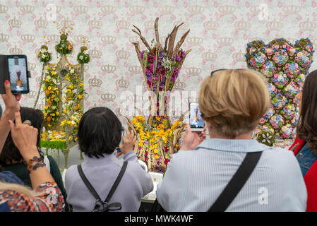 Die Besucher der RHS Chelsea Flower Show mit Fotografien von floralen Throne, die in die Floristen des Jahres Kategorie der Show eingegeben worden sein. Stockfoto