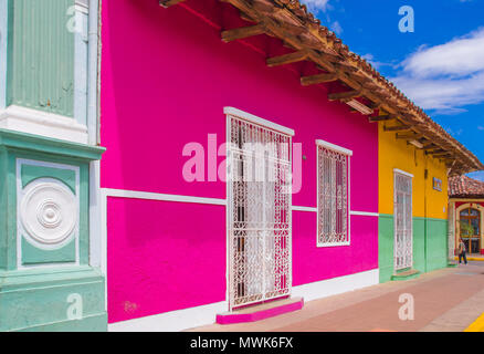 GRANADA, Nicaragua, Mai 14, 2018: Outdoor Ansicht der Fassade Gebäude mit rosa Wand, Tür und Dach in einem wunderschönen blauen Himmel Hintergrund im historischen Zentrum von Granada Stockfoto