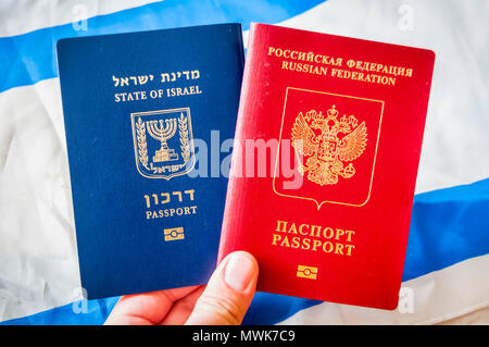 Hand mit zwei ausländischen Pass: der Pass des Staates Israel und dem reisepass Russland (Russische Föderation), doppelte Staatsbürgerschaft Konzept Bild Stockfoto