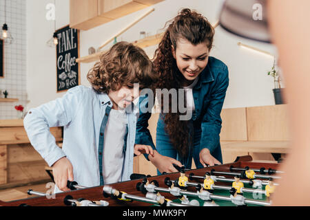 Porträts der glücklichen Mutter und Sohn spielen Tabelle footbal Stockfoto