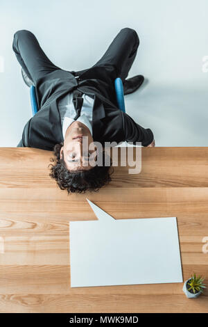 Draufsicht des Geschäftsmannes liegen auf dem Tisch mit leeren Sprechblase Stockfoto