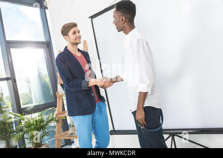 Multiethnischen jungen Unternehmer die Hände schütteln Nach einem Treffen im Büro Stockfoto