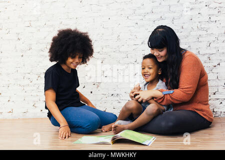 Mutter Lesung Märchen Fabel Geschichte für Kinder zu Hause. African American happy family Konzept Stockfoto