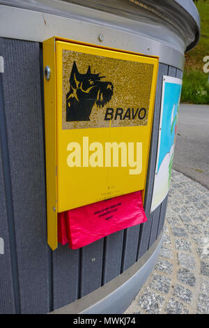 Dispenser an der Seite der Abfallbehälter der freien Beuteln für die Sammlung und Entsorgung von Hundekot in der Schweiz Stockfoto