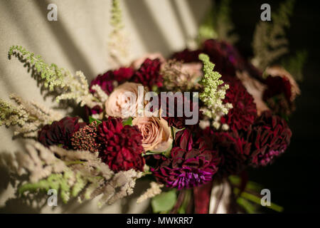 Hochzeit zerzaust Blumenstrauß mit weinroten Dahlien, creme Rosen und grünen. In der Nähe der horizontalen Foto Stockfoto
