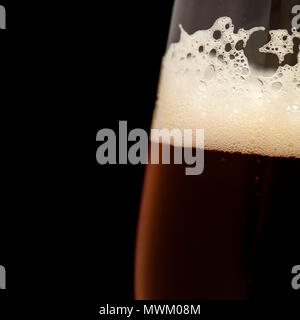 Frisch dunkles Bier in einem schnupperkurs Glas gegossen, auf Schwarz isoliert Stockfoto