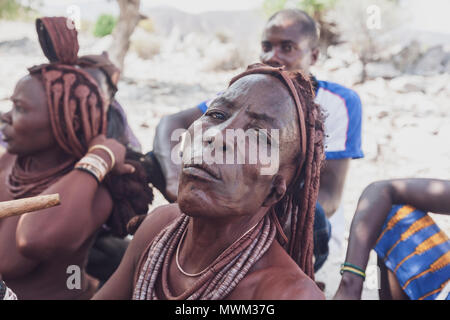 NAMIBE/ANGOLA - 28 Sep 2013 - Portrait der Afrikanischen ältere Frau, die zu einem Stamm mit Pfeife rauchen. Stockfoto