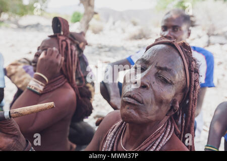 NAMIBE/ANGOLA - 28 Sep 2013 - Portrait der Afrikanischen ältere Frau, die zu einem Stamm mit Pfeife rauchen. Stockfoto