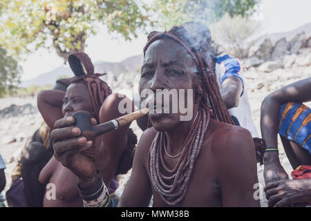 NAMIBE/ANGOLA - 28 Sep 2013 - Portrait der Afrikanischen ältere Frau, die zu einem Stamm mit Pfeife rauchen. Stockfoto