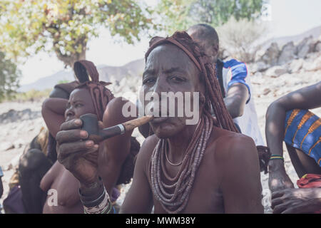 NAMIBE/ANGOLA - 28 Sep 2013 - Portrait der Afrikanischen ältere Frau, die zu einem Stamm mit Pfeife rauchen. Stockfoto