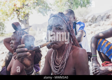 NAMIBE/ANGOLA - 28 Sep 2013 - Portrait der Afrikanischen ältere Frau, die zu einem Stamm mit Pfeife rauchen. Stockfoto