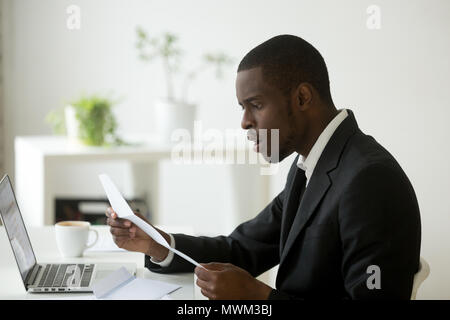 Schockiert African American Auslesen der empfangenen Dokumentation gedruckt Stockfoto