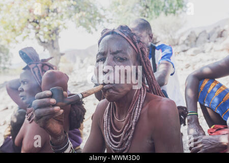 NAMIBE/ANGOLA - 28 Sep 2013 - Portrait der Afrikanischen ältere Frau, die zu einem Stamm mit Pfeife rauchen. Stockfoto