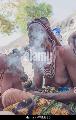 NAMIBE/ANGOLA - 28 Sep 2013 - Portrait der Afrikanischen ältere Frau, die zu einem Stamm mit Pfeife rauchen. Stockfoto