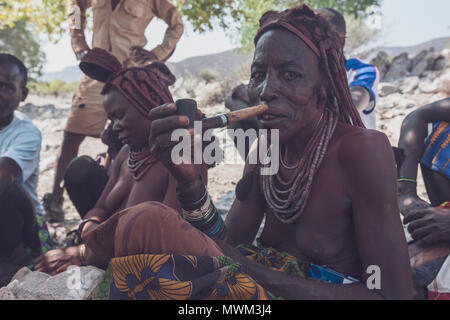 NAMIBE/ANGOLA - 28 Sep 2013 - Portrait der Afrikanischen ältere Frau, die zu einem Stamm mit Pfeife rauchen. Stockfoto