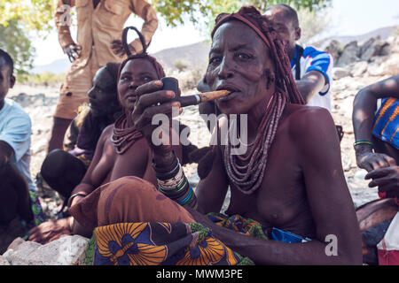 NAMIBE/ANGOLA - 28 Sep 2013 - Portrait der Afrikanischen ältere Frau, die zu einem Stamm mit Pfeife rauchen. Stockfoto