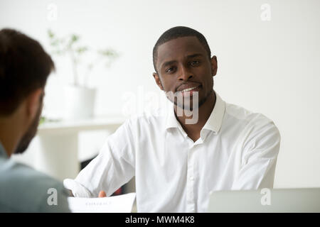 Lächelnd Afrikanische amerikanische Arbeiter bei Kamera schaut im Büro Stockfoto