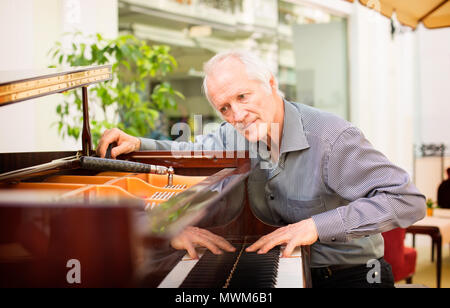 Ältere Musik instrument Techniker Tuning einer Klaviertastatur. Stockfoto