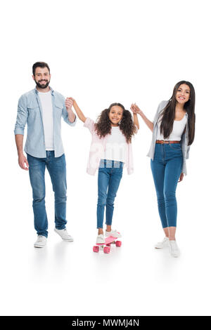 Glückliche Eltern halten sich an den Händen der süsse kleine Tochter stehen auf Skateboard Stockfoto