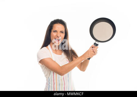 "Kreischen Hausfrau in Schürze, stehend mit Pfanne in den Händen, auf weissem isoliert Stockfoto