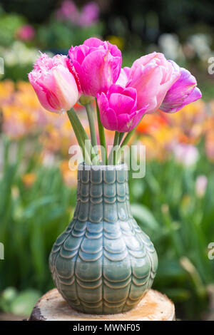 Ein rosa themed Tulip Anordnung in eine grüne Vase. Mit Tulipa 'Christmas Dream', Tulipa Tulipa 'Cacharel' und 'Pretty Princess' Stockfoto