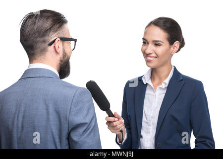 Gerne Journalistin interviewte Geschäftsmann in Anzug, isoliert auf weißem Stockfoto