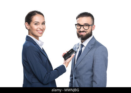 Lächelnd weibliche Journalistin interviewte eine Geschäftsmann, isoliert auf weißem Stockfoto
