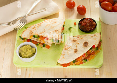 Pflanzliche Quesadillas mit Broccoli, Paprika, Tomaten, Paprika und Käse mit Guacamole und Tomaten-dip. Stockfoto