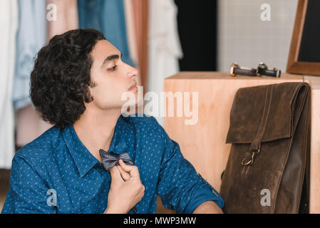 Seitenansicht des gutaussehenden jungen Mann die Wahl Bow Tie, während Sie in der Boutique suchen Stockfoto