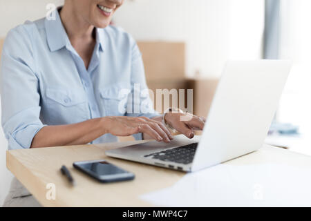 7/8 Schuß von lächelnden reife Geschäftsfrau mit Laptop Stockfoto