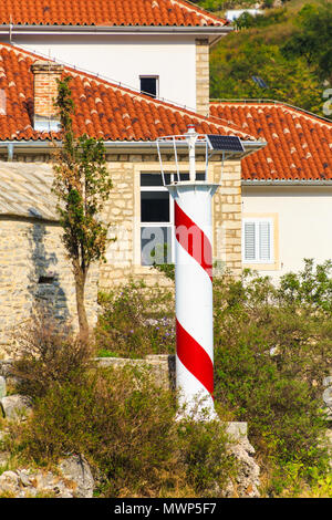 Rot-weiße Leuchtturm von alten Gebäuden in Kotor Stockfoto