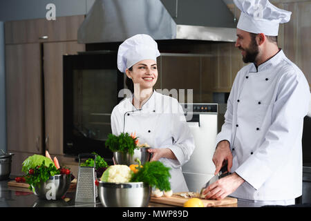 Professionelle Köche diskutieren Rezeptur und Kochen auf Küche Stockfoto