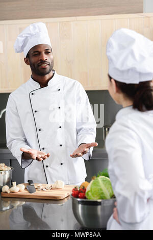 Multirassischen Köche Team diskutieren, Rezeptur und Kochen auf Küche Stockfoto