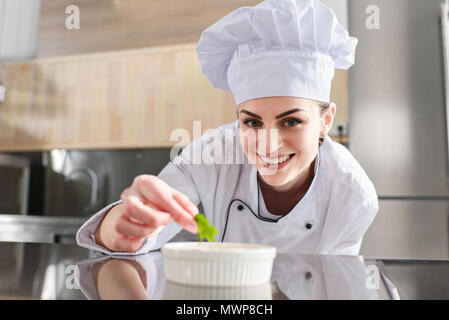 Köchin garnieren Teller auf Restaurant Küche Stockfoto