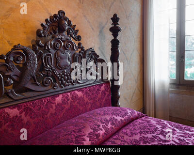 Torreglia, Italien, 26. Mai 2018: antikes Himmelbett mit geschnitzten Kopfteilen in der Villa dei Vescovi, einem Venezianischen Renaissance Villa. Currentl Stockfoto