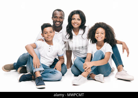 Schöne glückliche afroamerikanische Familie zusammen zu sitzen und lächeln in die Kamera auf Weiß isoliert Stockfoto