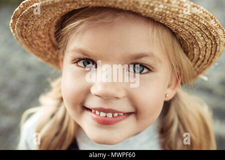 Portrait von lächelnden Mädchen im Stroh Hut an Kamera suchen Stockfoto