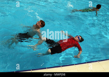 Boy zeigen Scouts Truppe 965 Kuwait wie Crawl und Schwimmer während ihre schwimmen Verdienst Abzeichen Prüfung April 28, Camp Arifjan, Kuwait zurück. Bereich Support Group-Kuwait Host Nation Angelegenheiten Gastgeber dieser Veranstaltung, die 23 Truppen Verdienstabzeichen in Schwimmen und Fahrzeugsicherheit zu verdienen gab. Stockfoto