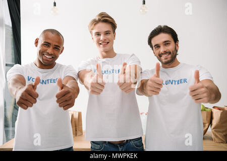 Gruppe von Multiethnischen Freiwilligen zeigen Daumen hoch Stockfoto