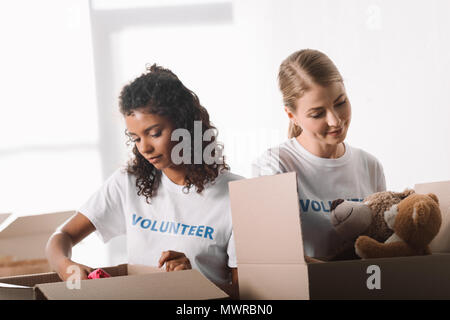 Schöne junge weibliche Freiwillige Verpackung Spielzeug für Nächstenliebe Stockfoto