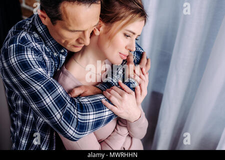 Hohe Betrachtungswinkel von Mann umarmt Frau zu Hause Stockfoto