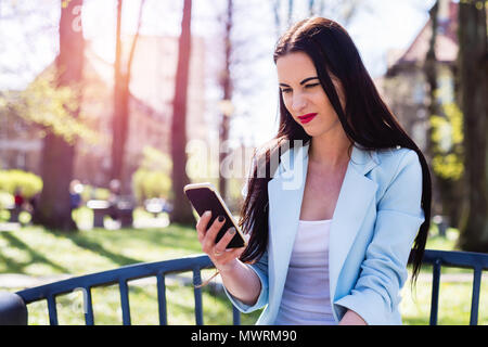 Ein Angewidertes frau sieht das Telefon. Die überraschten Mädchen liest etwas seltsam, verwirrend. Stockfoto