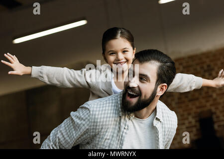 Gerne Vater huckepack Fahrt zu jungen Tochter zu Hause Stockfoto