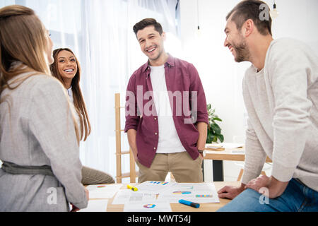 Lächelnd multiethnischen Kollegen diskutieren neue Marketing Projekt am Arbeitsplatz im Büro Stockfoto