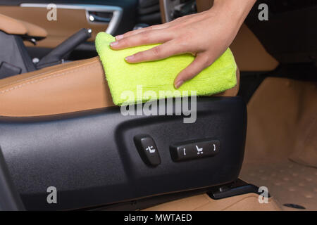 Eine Frau hand mit gelb Mikrofasertuch Reinigung im Auto Sitzungen Strom. Stockfoto