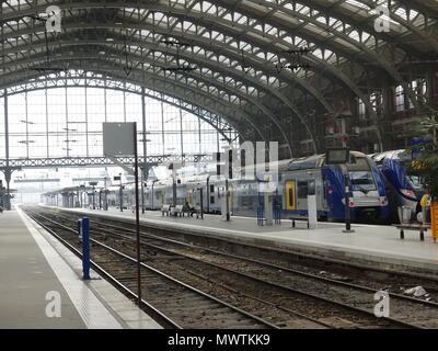 Personenzüge geparkt in der, fast leer, Bahnhof Lille Flandres, während junge Frau wartet auf einer Bank, Lille, Frankreich Stockfoto